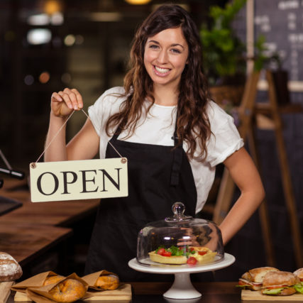 girl holding open for business sign